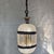 A dramatic vintage Hollywood Regency swag lamp featuring patterned clear glass, antiqued gold-tone metal detailing,...