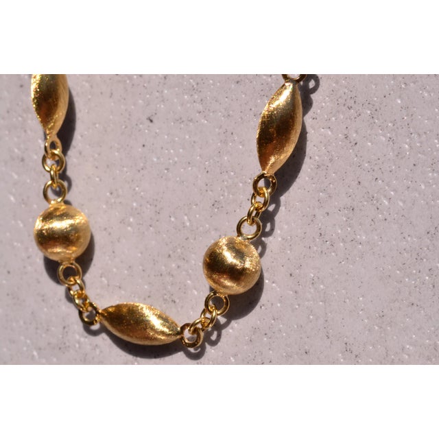 The Andorra: Outstanding Italian Station Necklace in Yellow Gold. The necklace features 18 karat yellow gold globe shaped...
