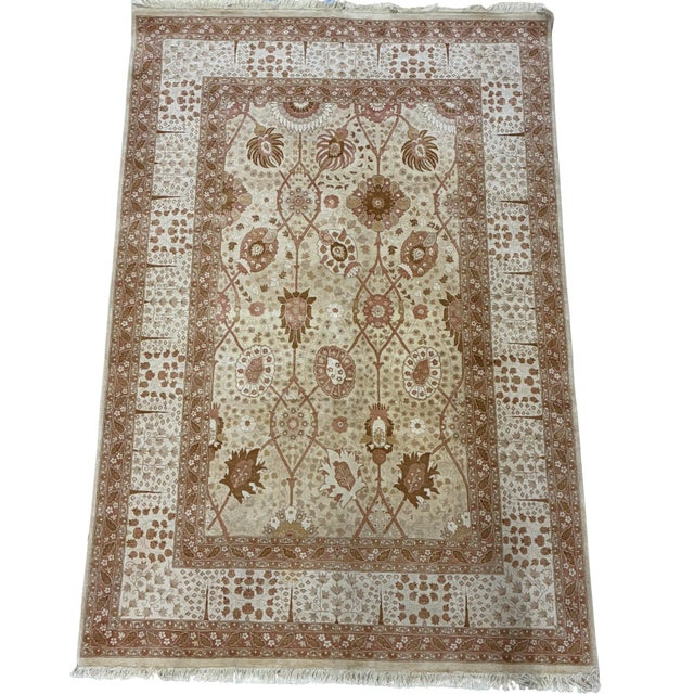 A finely hand-knotted wool area rug inspired by classic Persian Tabriz designs, featuring an elegant allover floral garden...
