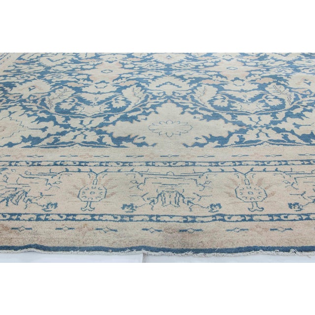 An early 20th century North Indian rug, the midnight blue field with an allover beige trellis of leafy vines and...