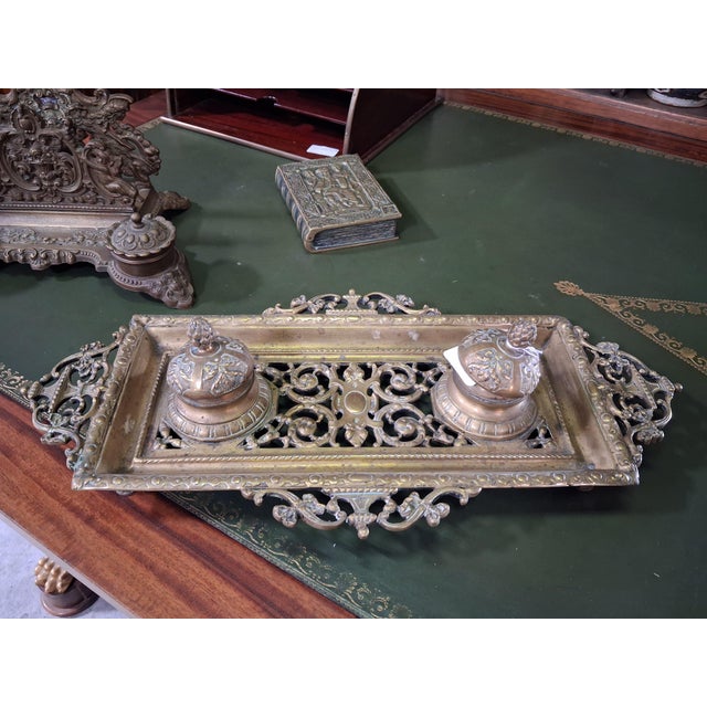 A 19th-century bronze desk inkwell with a rich openwork design inspired by the Neo-Renaissance style. Rectangular in...