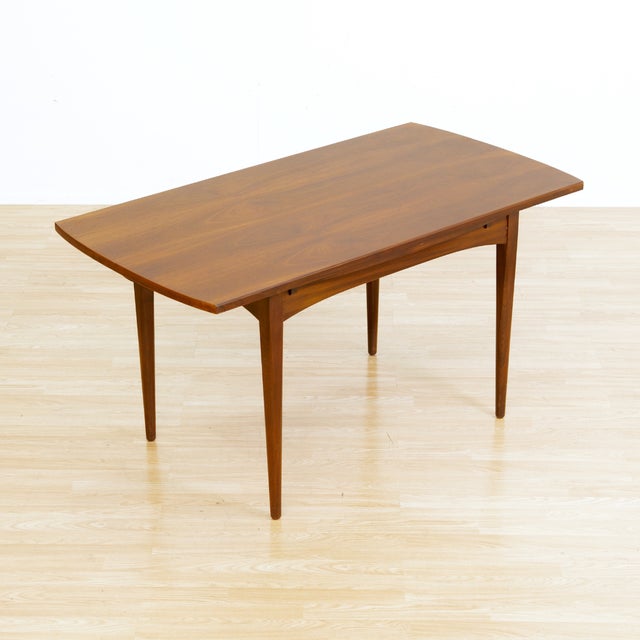 This vintage mid-century extending dining table was designed and manufactured by 'Elliots of Newbury' of Berkshire,...
