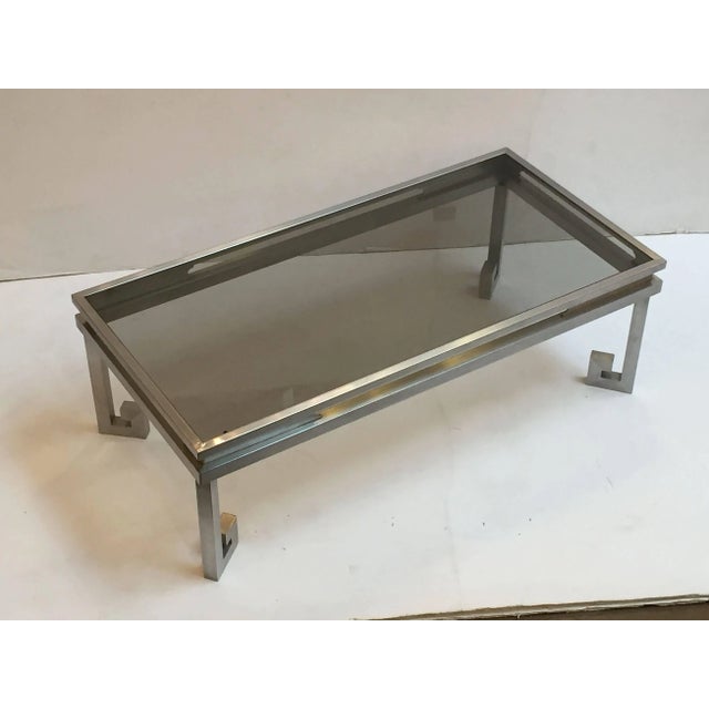 A fine large French rectangular coffee or cocktail low table, with an inset smoked glass top on a brushed steel support...