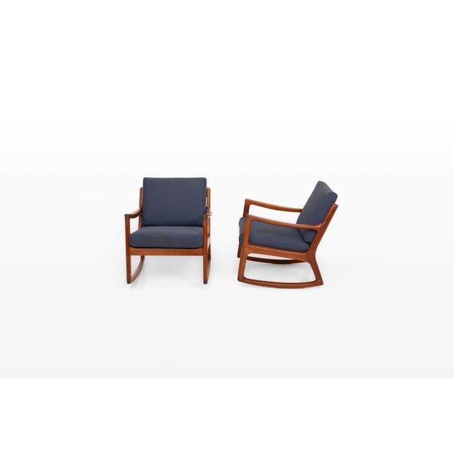 An elegant pair of vintage rocking chairs designed by ole wanscher for cado, denmark. The warm wooden frames feature...