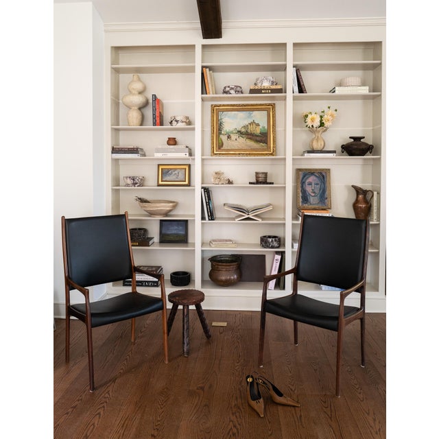 A pair of high-back chairs designed by Johannes Andersen and made in Denmark in 1960. Sculptural solid rosewood frames...