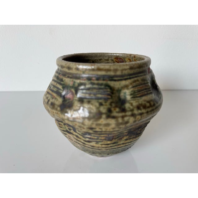 A beautifully handcrafted 1980s vintage art pottery vase by Nason, featuring a rich green speckled glaze with earthy brown...