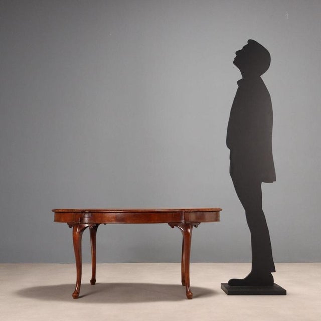 Walnut biscuit table, resting on four wavy legs. Italy, 20th century. This piece is attributed to the mentioned...