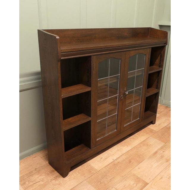Arts and Crafts Glazed Liberty Bookcase with Open Shelving This piece is being offered from a dispersal sale of Arts and...