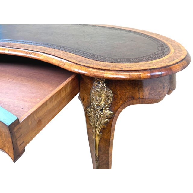 A stunning quality 19th-century Victorian burr walnut kidney-shaped writing table, having attractive old leather with...
