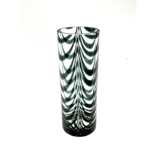 A striking, heavy cylindrical vase made of hand-blown thick glass from the 1970s, featuring a dramatic, dark green...