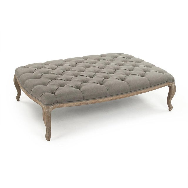 The Maison Rectangular Ottoman from Zentique in grey linen features a plush button-tufted top on a weathered oak frame...