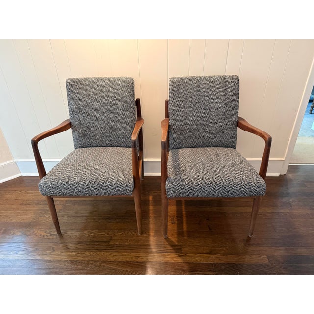 Elegant pair of vintage mid-century modern lounge chairs featuring beautifully sculpted walnut frames, tapered legs, and...