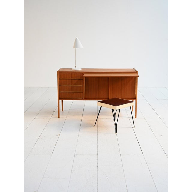 Teak sideboard with four drawers, a foldaway desk, and a compartment with sliding doors and internal shelves. A 1960s...