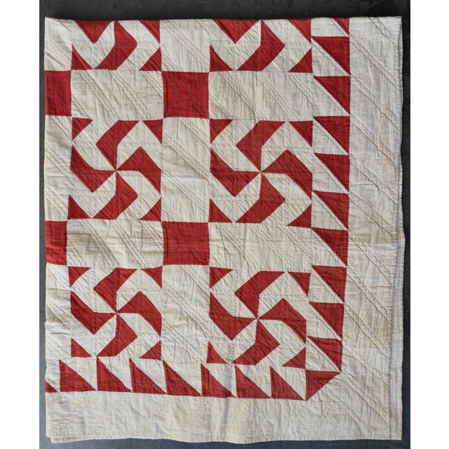 Hand-stitched and hand-quilted made cotton quilt in a cheerful red pinwheel pattern on an off-white ground. Found in New...