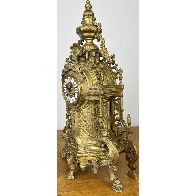 An impressive Vintage brass clock with an exceptionally ornate decorative design and striking architectural styling....