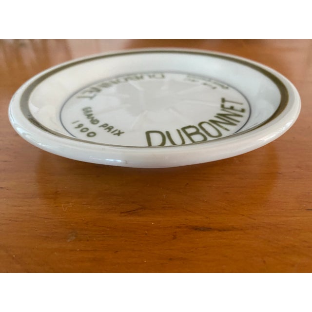 A Parisian cafe tip plate. Made to advertise Dubonnet and the Grand Prix 1900.