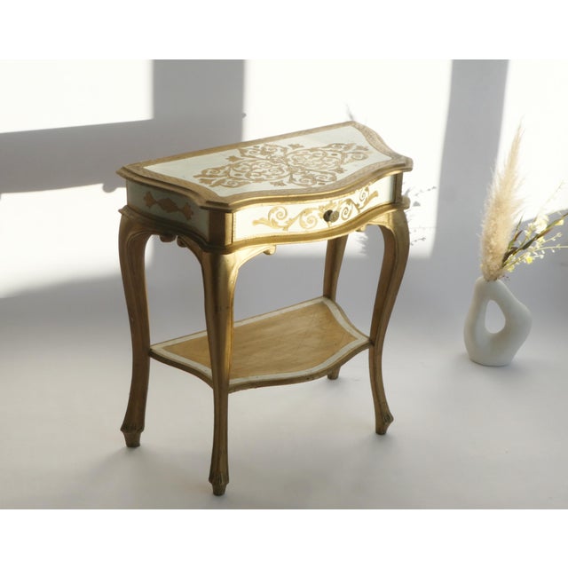 A mid century Florentine wall table in beautiful golden and white colours. The Florentine console has a drawer and a shelf...