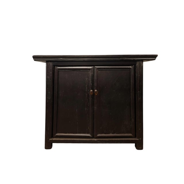 Handmade from solid wood, this antique cabinet features a traditional dark finish and a classic overhanging top design...