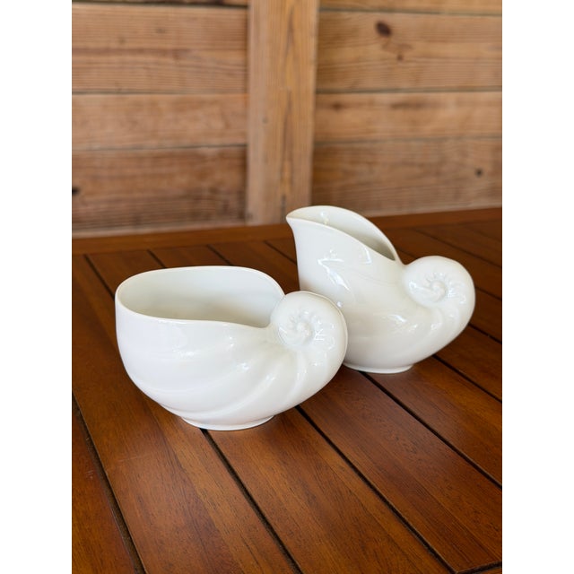 A charming vintage Hutschenreuther porcelain sugar bowl and creamer set, beautifully modeled in the form of nautilus...