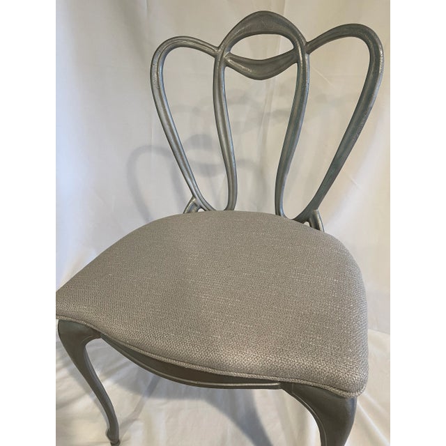 Grey iron chair reupholstered in iridescent grey fabric with welt