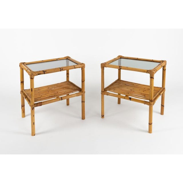Midcentury amazing pair of side tables or bedside tables with two-tier in bamboo, rattan and smoked glass top. Made in...