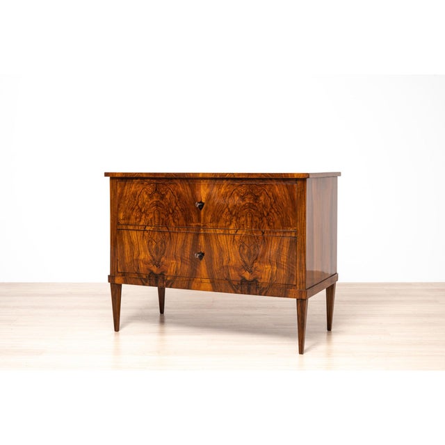 Elegant two-drawer Biedermeier commode, originating from Germany or Central Europe and dating to circa 1850. The piece is...