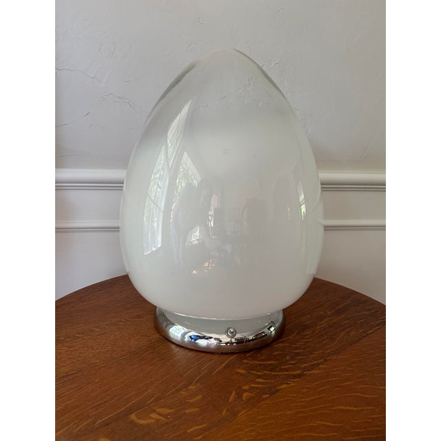 This eclectic egg-shaped table lamp captures the funky boho vibe of the 1970s. The large bulbous blown glass globe has...