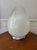 This eclectic egg-shaped table lamp captures the funky boho vibe of the 1970s. The large bulbous blown glass globe has...