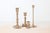 Set of four vintage brass candlestick holders in varied silhouettes and heights. The mixed shapes create an elegant,...