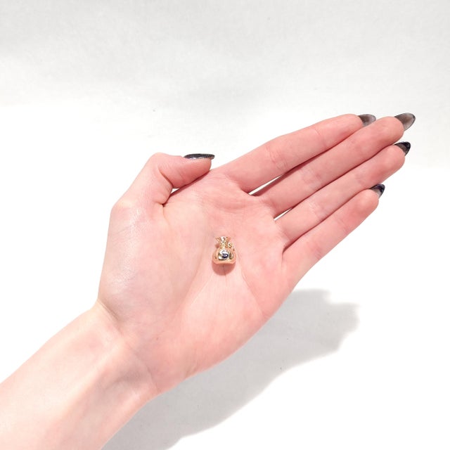 A fine Mid-Century charm for a bracelet. In 14 karat yellow gold. In the form of a figural, three-dimensional money bag or...