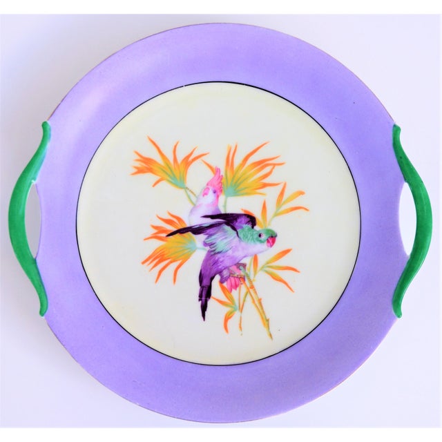 This is a beautiful cake plate. This plate is about of 10" in diameter and has a pretty lilac border with two cockatiel in...