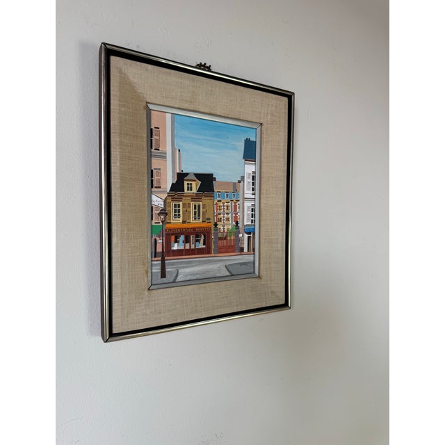 Charming vintage folk art cityscape painting by Lilian Latal, executed in oil on masonite. The work captures a colorful...