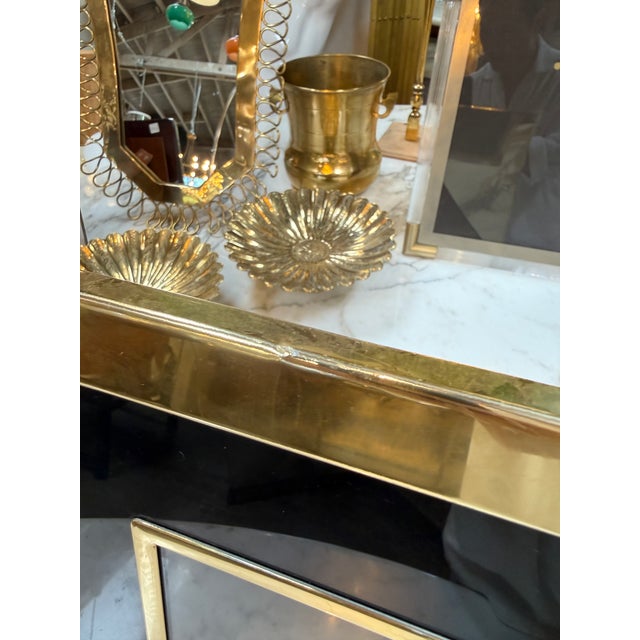 Elegant vintage picture frame featuring a polished brass border with a contrasting black glass surround. Its bold...