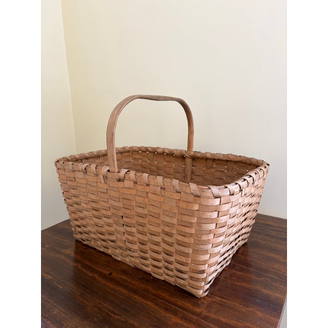 A beautifully woven early 20th century American splint oak basket with warm honeyed tones and a tightly constructed...