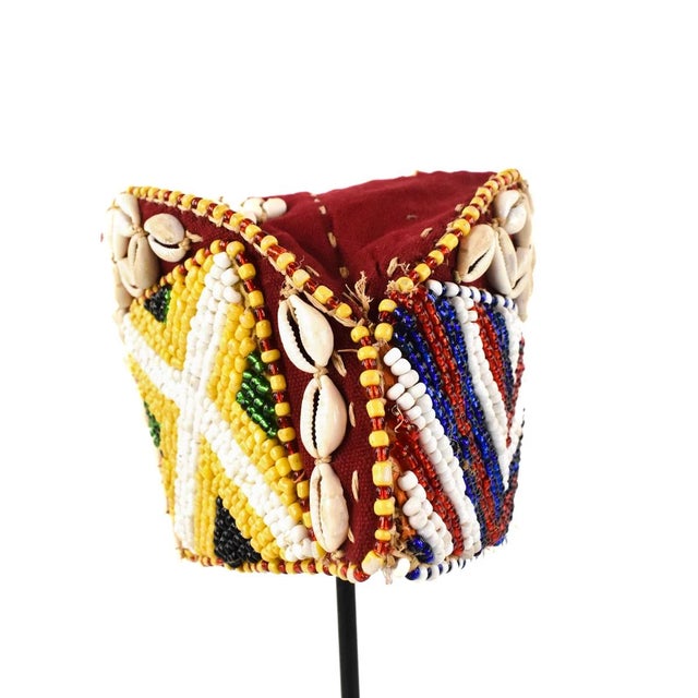 This intricately handwoven hat is covered in glass beads and cowrie shells. The Kuba beaded noble's hat with cowrie shells...