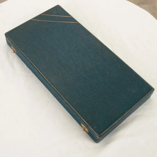 Dimensions: 1-½”H x 14”W x 7”D Encased in a navy blue leather box and protected by gold velvet, this set of 4 serving...