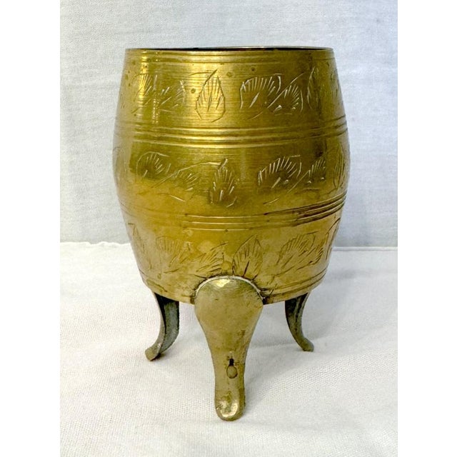 Etched brass vase in the form of an egg, set on feet. Foliate decoration. Numbers and, "India" etched on the underside....