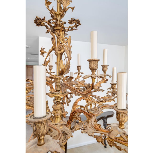 Large and highly decorative gilt metal chandelier in a French Baroque/Rococo Revival style, featuring an elaborate...