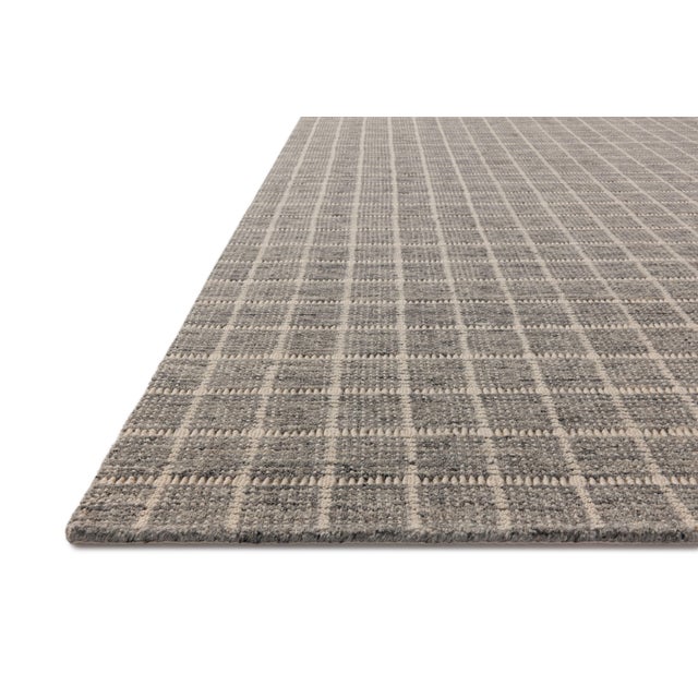 The Cedar Collection by Amber Lewis x Loloi is a hand-loomed area rug with a clean gridded design in contrasting ivory....