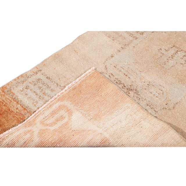 Beautiful vintage Turkish hand-knotted wool runner with a beige field. This rug has peach and tan accents in an all-over...