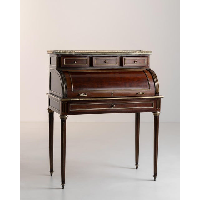Embodying the refined classicism of the Louis XVI era, this exquisite cylinder desk commands attention with its harmonious...
