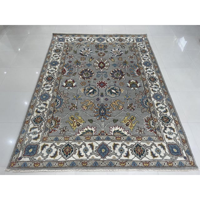 This gray wool rug features a hand knotted pile construction in the traditional Sarouk style. Crafted in India, the rug...