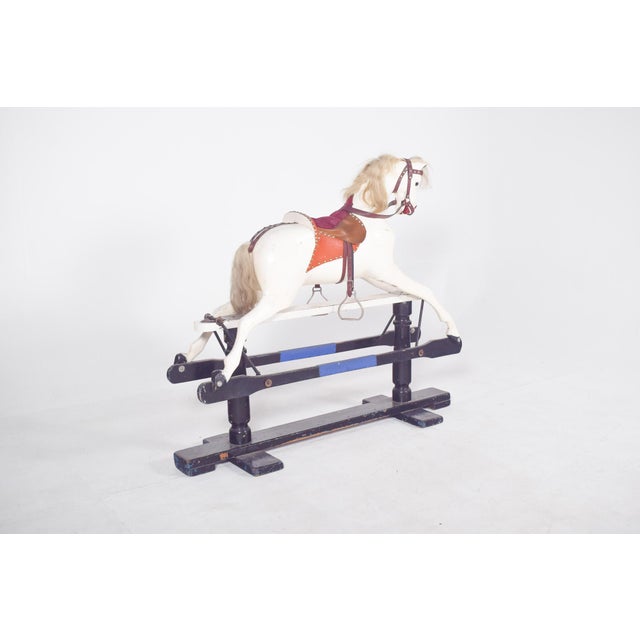 Toy horse in painted wood. It has a carefully sculpted body with well-defined anatomical shapes, a mane and tail made from...