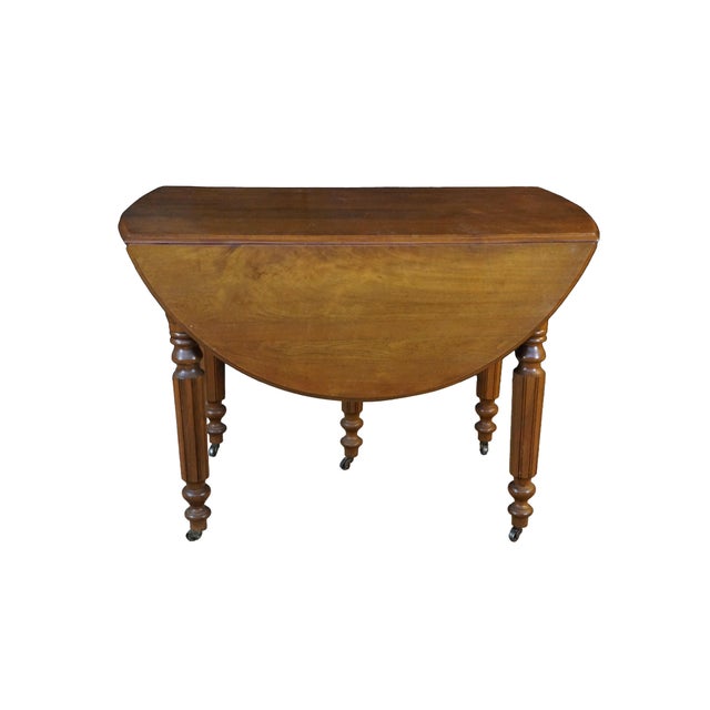 This antique 19th century Victorian-era mahogany drop-leaf dining table showcases classic 19th-century styling,...