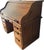 This vintage Postmaster oak roll-top desk features a distinctive curved tambour top and traditional carved wooden drawer...
