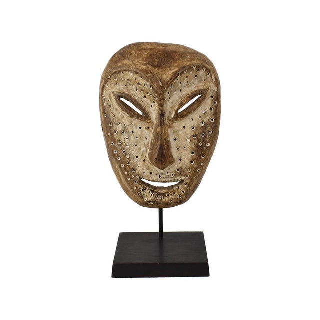 Bring a piece of African culture into your home with our Lega Mask from Congo on a custom metal stand. Hand-carved from...