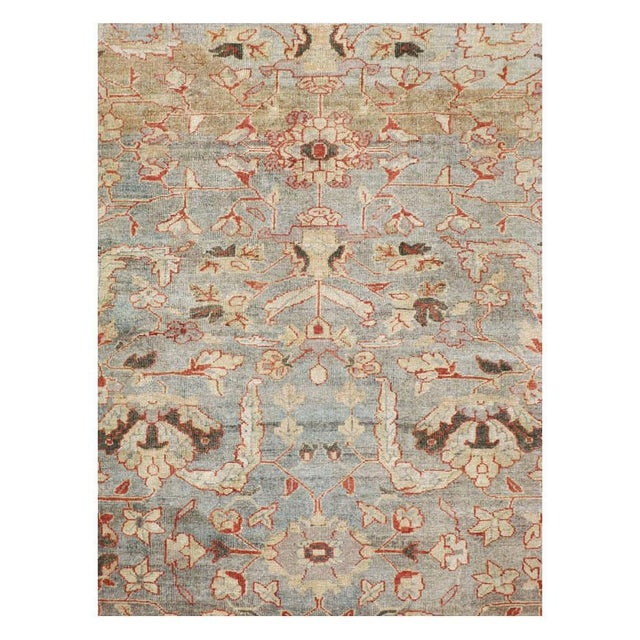 This early 20th-century Persian Mahal carpet presents a refined floral composition across a soft blue field, enriched with...