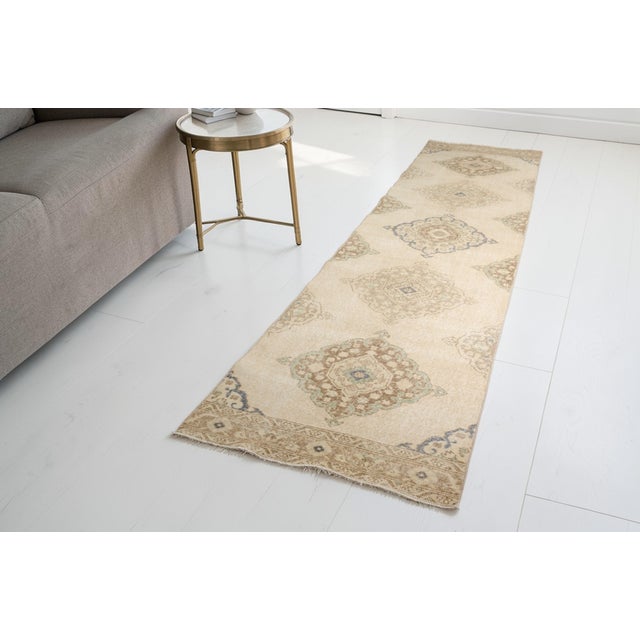 This is a vintage Turkish Oushak rug from the Mid 20th Century. The piece was hand-knotted.