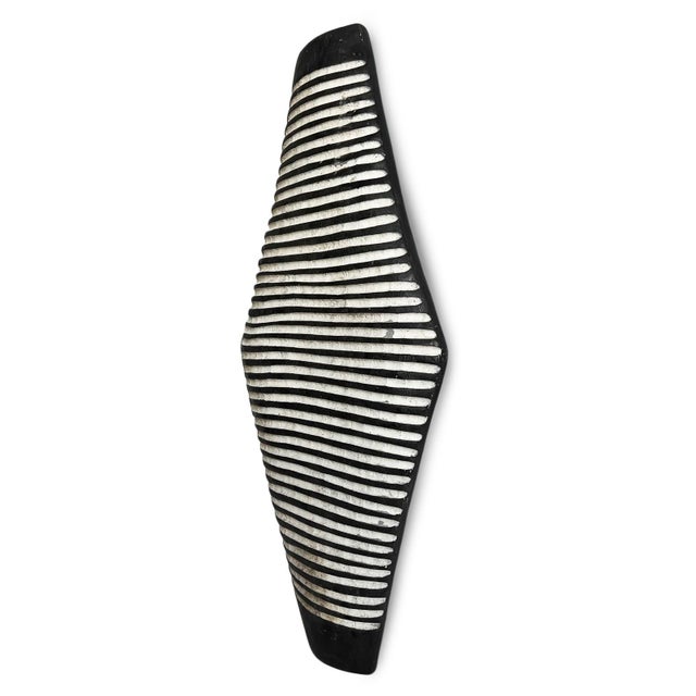 Vintage elongated black and antiqued white carved wood Zulu shield. Traditional South African Zulu shields date back to...