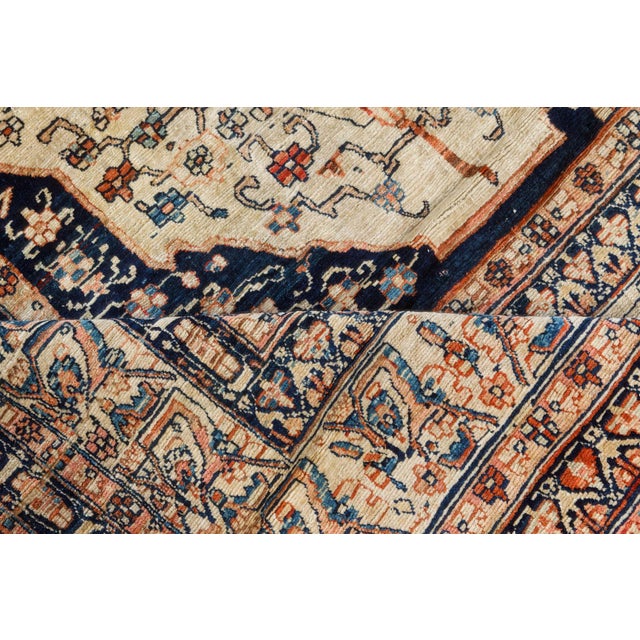 A late 19th century antique Persian Tabriz carpet, the sand field dominated by a large tree with angular flowering vines...